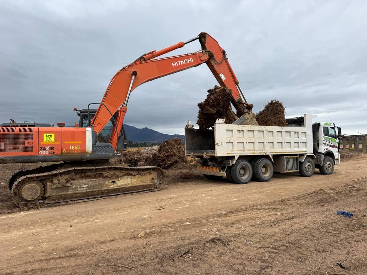 DKL excavator doing earthworks in vineyard area with mountains